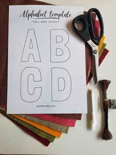 a printable alphabet is sitting on top of some crafting supplies