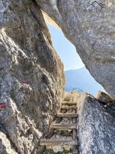 stairs going up to the top of a large rock formation with mountains in the background