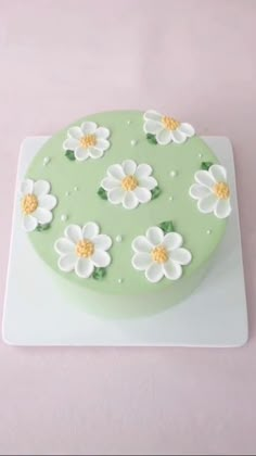 a green cake with white flowers on it