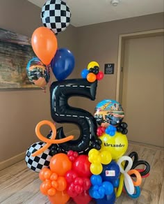 a birthday cake made out of balloons with the number five on top