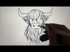 someone is drawing a bull's head on the paper with a pencil and marker