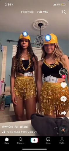 two women wearing gold sequins and matching hats are standing in front of a mirror