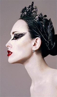 a woman with black makeup and feathers on her head