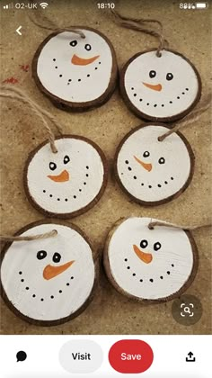 four snowman ornaments are hanging from twine on the floor, with string attached to them