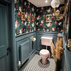 a bathroom with floral wallpaper and green walls