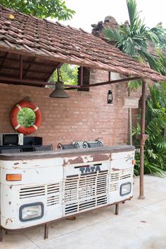 an old bus parked in front of a brick building with a life preserver on top