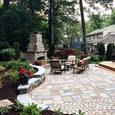 an outdoor patio with stone pavers and seating area, surrounded by greenery and trees