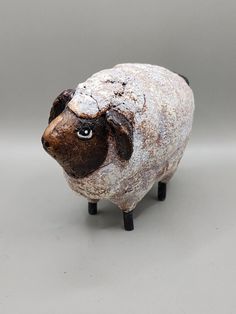 a brown and white sheep figurine sitting on top of a gray tablecloth