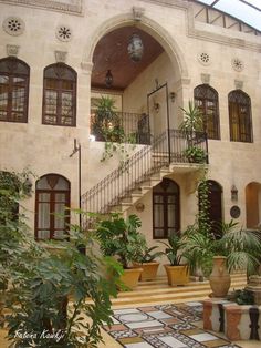 the entrance to a large house with potted plants