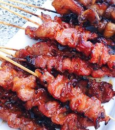 several skewers of meat on a white plate