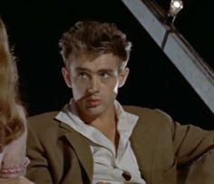 a man and woman sitting next to each other in front of a stair case with lights on