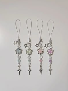 four different colored charms hanging from hooks