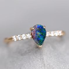 Fantastic Australian Opal Jewelry Stylish Two-Color Australian Boulder Opal & Diamond Engagement Ring 18K Yellow Gold.  Free Domestic USPS First Class Shipping! Free Gift Bag/Box with every order! Every Opal piece is Unique. We only use high quality Natural Australian Opals ( NO synthetics or imitations). Quality is our commitment. Please do not hesitate to contact me if you have any questions or concerns:) *All pictures were taking under the natural light. ABOUT THIS PRODUCT 18K Yellow Gold Australian Boulder Opal, 0.55 ct 8 Diamond: 0.113 ct Opal Size: 7 x 4.5 mm Opal Brightness: B4 Very Bright Opal Color: Reflects Red, Green, and Yellow Colors. Ring Size: 7 Occasion: Engagement/Anniversary Re-sizing: The ring size is 7.  We size down the ring for free, and $20 extra for sizing up.  Ther Multicolor Pear-shaped Jewelry For Anniversary, Opal Diamond Engagement Ring, Rarest Gemstones, Gold Opal Engagement Ring, Boulder Opal Jewelry, Opal Promise Ring, Australian Opal Jewelry, Promise Bracelet, Australian Black Opal