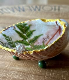 a ring sits in a decorative bowl on a table