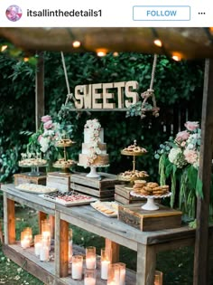 an outdoor dessert table with candles and cakes