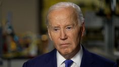 an older man in a suit and tie looking off to the side with serious expression on his face