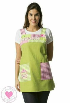 a woman wearing an apron and smiling at the camera with her hands on her hips