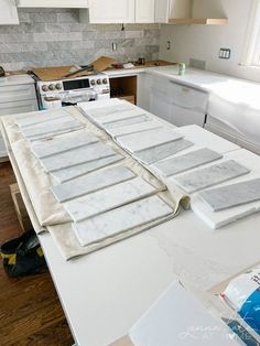 the kitchen counter is covered in white marble tiles and ready to be installed into the wall