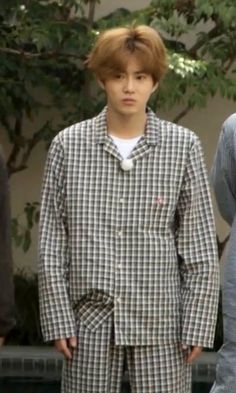 two men standing next to each other in pajamas and ties, one with brown hair