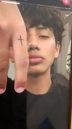 a man with a cross tattoo on his finger