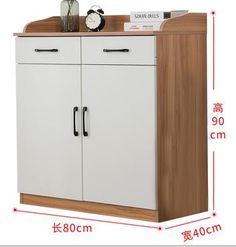 the cabinet is white and brown with black handles