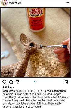 someone is using needle tip to sew a deer's head on a pillow