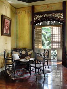 a living room filled with furniture next to a window covered in paintings and windowsills