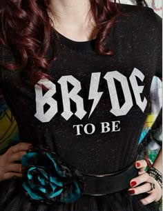 a woman with red hair wearing a black t - shirt that says bride to be