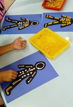 children are making their own paper cutouts at the table