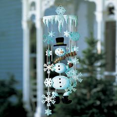 a snowman wind chime hanging from the side of a house