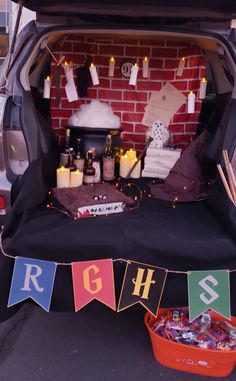 the trunk of a car is decorated with letters and buntings, candles, and other items