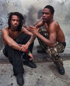 two men sitting next to each other on the ground