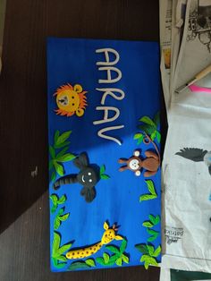 a blue sheet cake with animals and trees on it sitting on a table next to paper bags