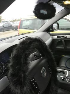 the interior of a car with black fur and steering wheel covers on it's dashboard