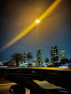 an image of a city at night taken from the inside of a car with its lights on