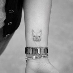 a small dog tattoo on the wrist