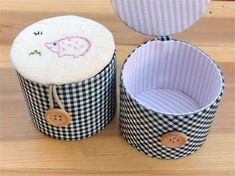 two black and white checkered baskets sitting on top of a wooden table next to each other