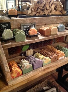 a wooden shelf filled with lots of different types of soaps on top of each other