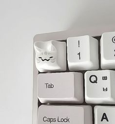 a computer keyboard with white keys that have black and white cat faces on the keys