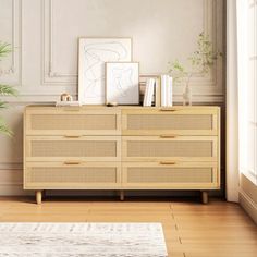 an empty room with a dresser and potted plant on the floor next to it