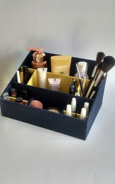 a blue container filled with lots of makeup and other items on top of a white table