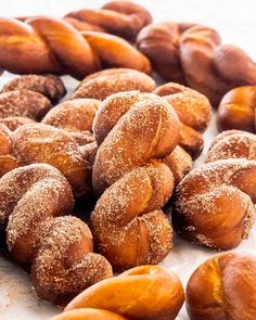 powdered sugar coated doughnuts on a white surface