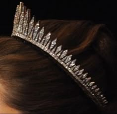 a woman wearing a tiara on top of her head with hair in the back