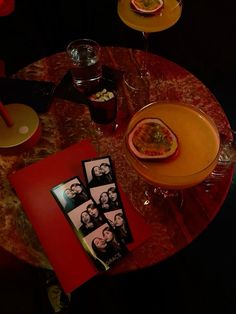 a table topped with pictures and drinks on top of a wooden table next to plates