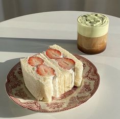 a plate topped with sliced up strawberries next to a cup of coffee on a table