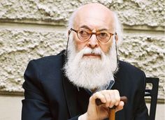 an old man with a long white beard and glasses sitting in a chair holding a cane