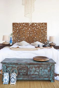 a bed with a wooden headboard sitting on top of it