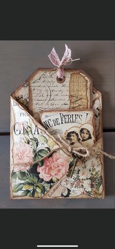 an old fashioned envelope is decorated with pink flowers and vintage postcards, as well as a bow