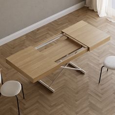 a wooden table sitting on top of a hard wood floor next to two white chairs