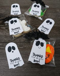 halloween treat bags filled with treats on top of a wooden table